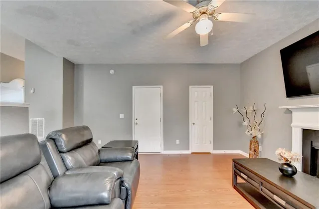 a living room with furniture a flat screen tv and a fireplace