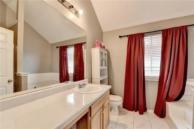 a bathroom with a tub sink and mirror