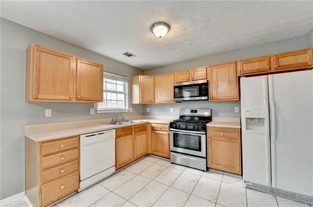 a kitchen with granite countertop appliances cabinets and a sink