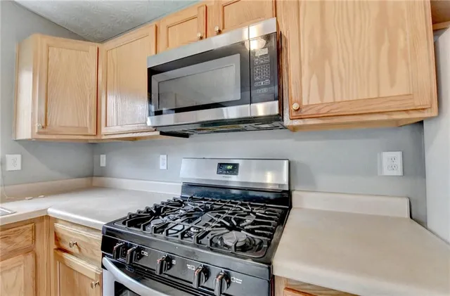 a kitchen with stainless steel appliances granite countertop a stove and a microwave