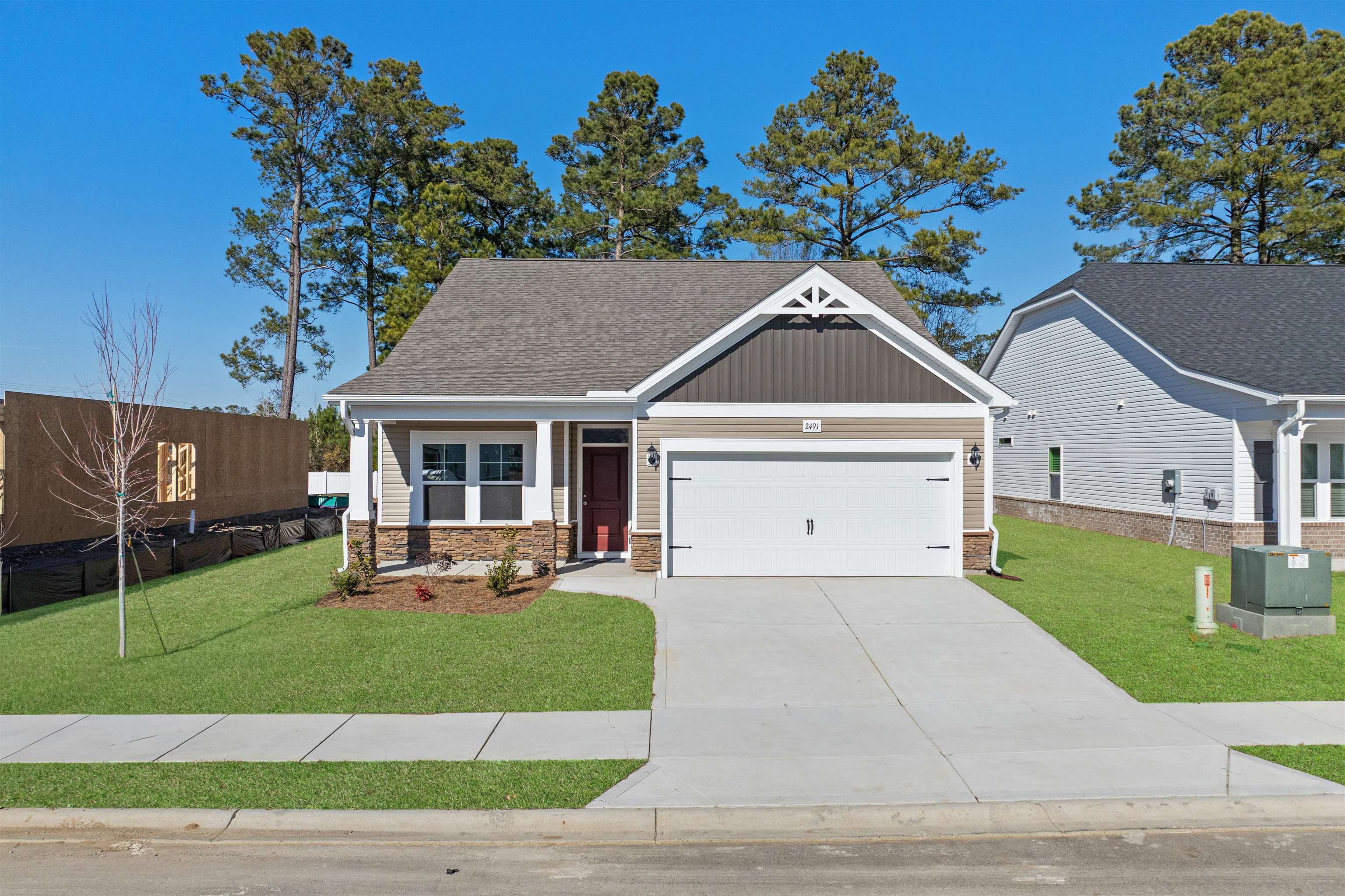 Craftsman house featuring covered porch, concrete driveway, an attached garage, stone siding, and a shingled roof