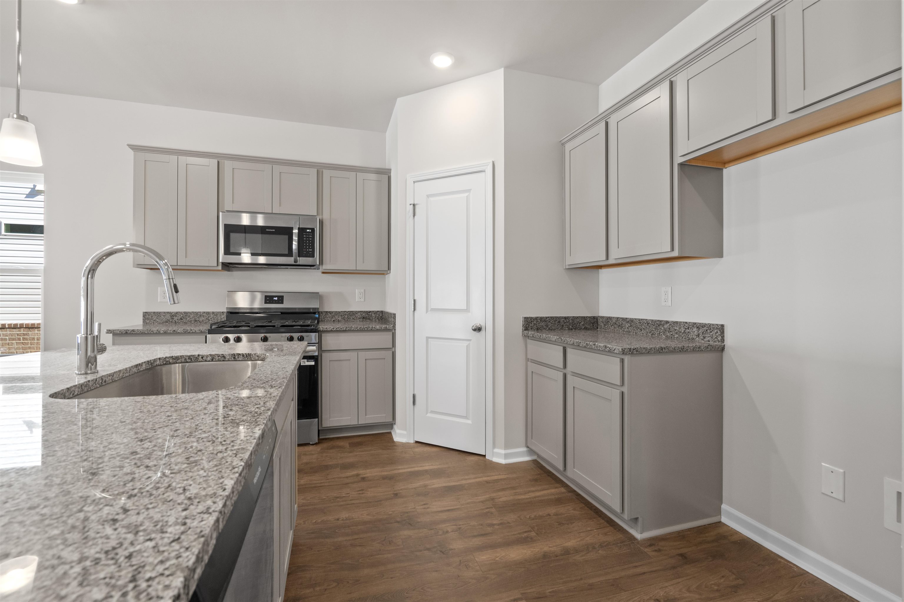 2491 Campton Loop Conway, SC 29527 - Photo 13 of 38 Kitchen with gray cabinets, stainless steel appliances, dark wood-style flooring, light stone counters, and decorative light fixtures