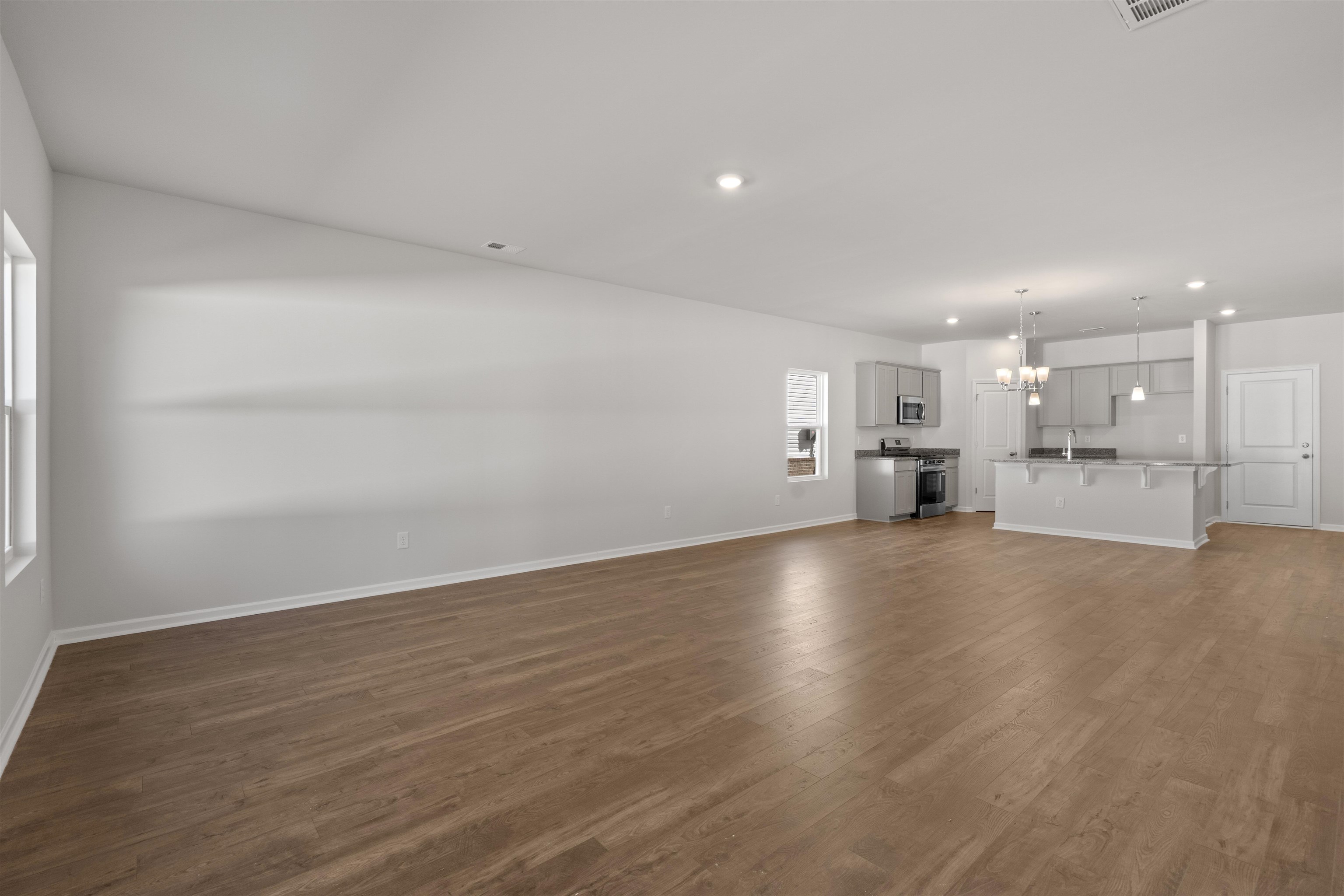 2491 Campton Loop Conway, SC 29527 - Photo 26 of 38 Unfurnished living room featuring dark wood-type flooring, a chandelier, and recessed lighting