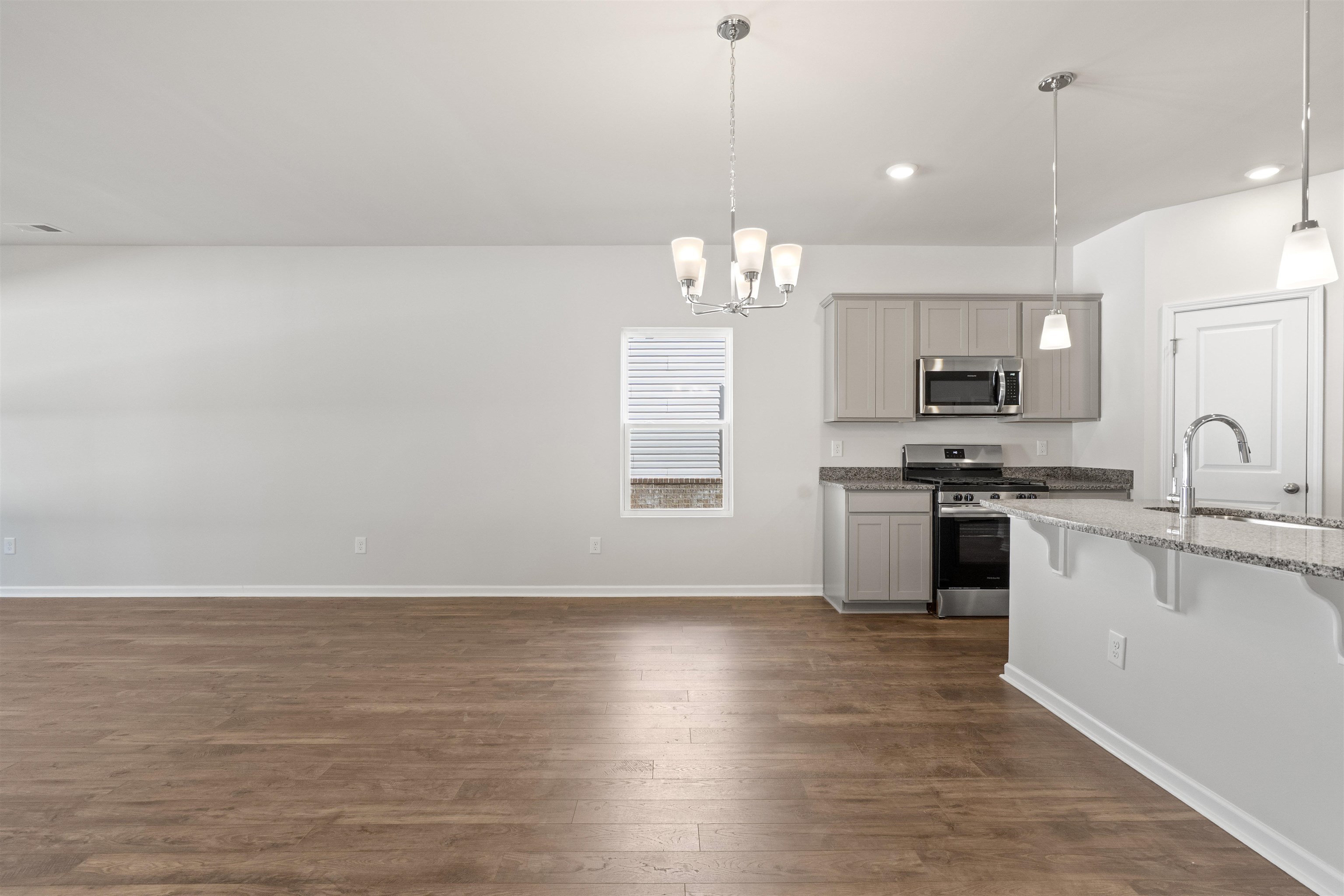 2491 Campton Loop Conway, SC 29527 - Photo 27 of 38 Kitchen with appliances with stainless steel finishes, dark wood finished floors, a breakfast bar area, a chandelier, and pendant lighting