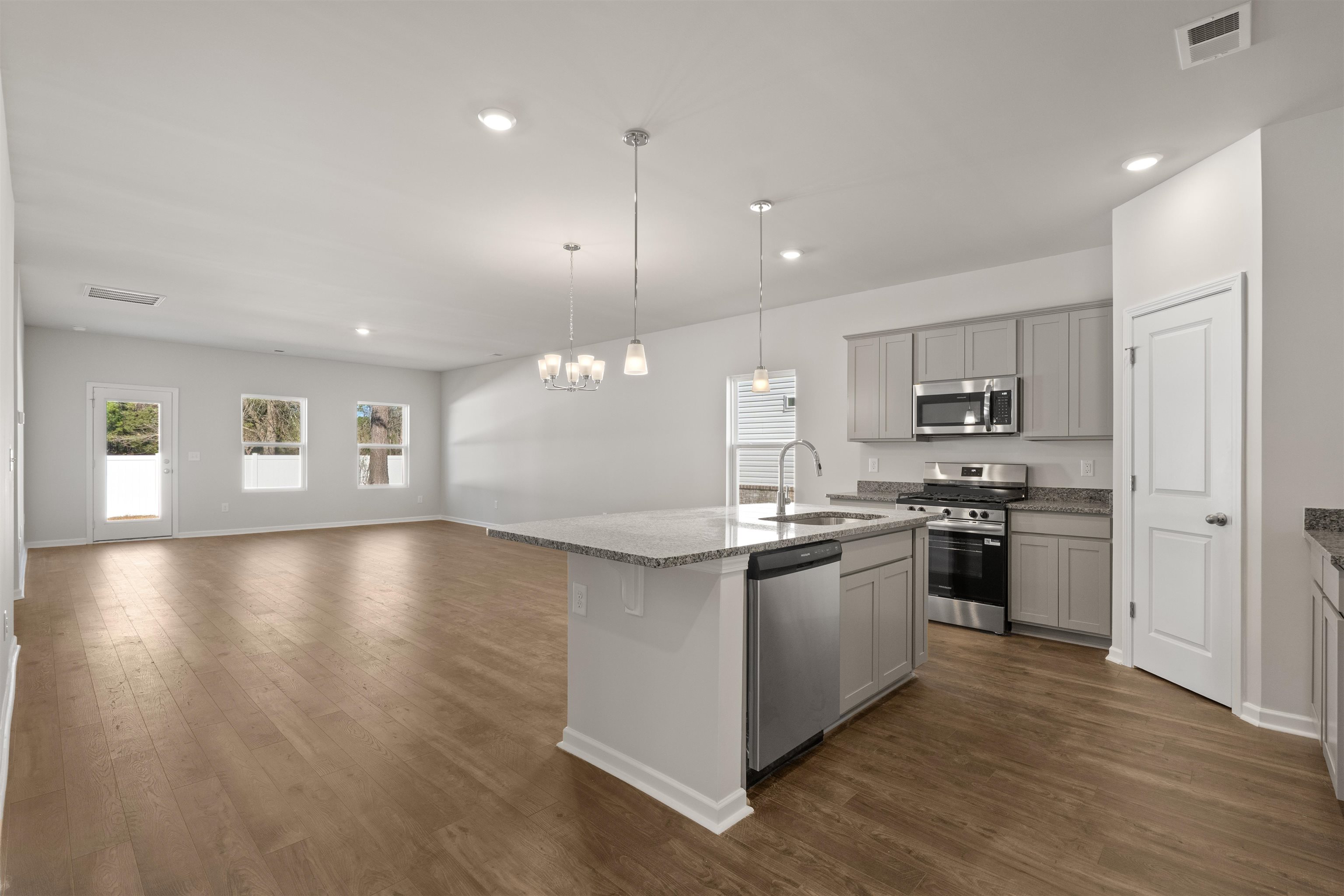 2491 Campton Loop Conway, SC 29527 - Photo 6 of 38 Kitchen featuring appliances with stainless steel finishes, dark wood finished floors, pendant lighting, light stone countertops, and recessed lighting