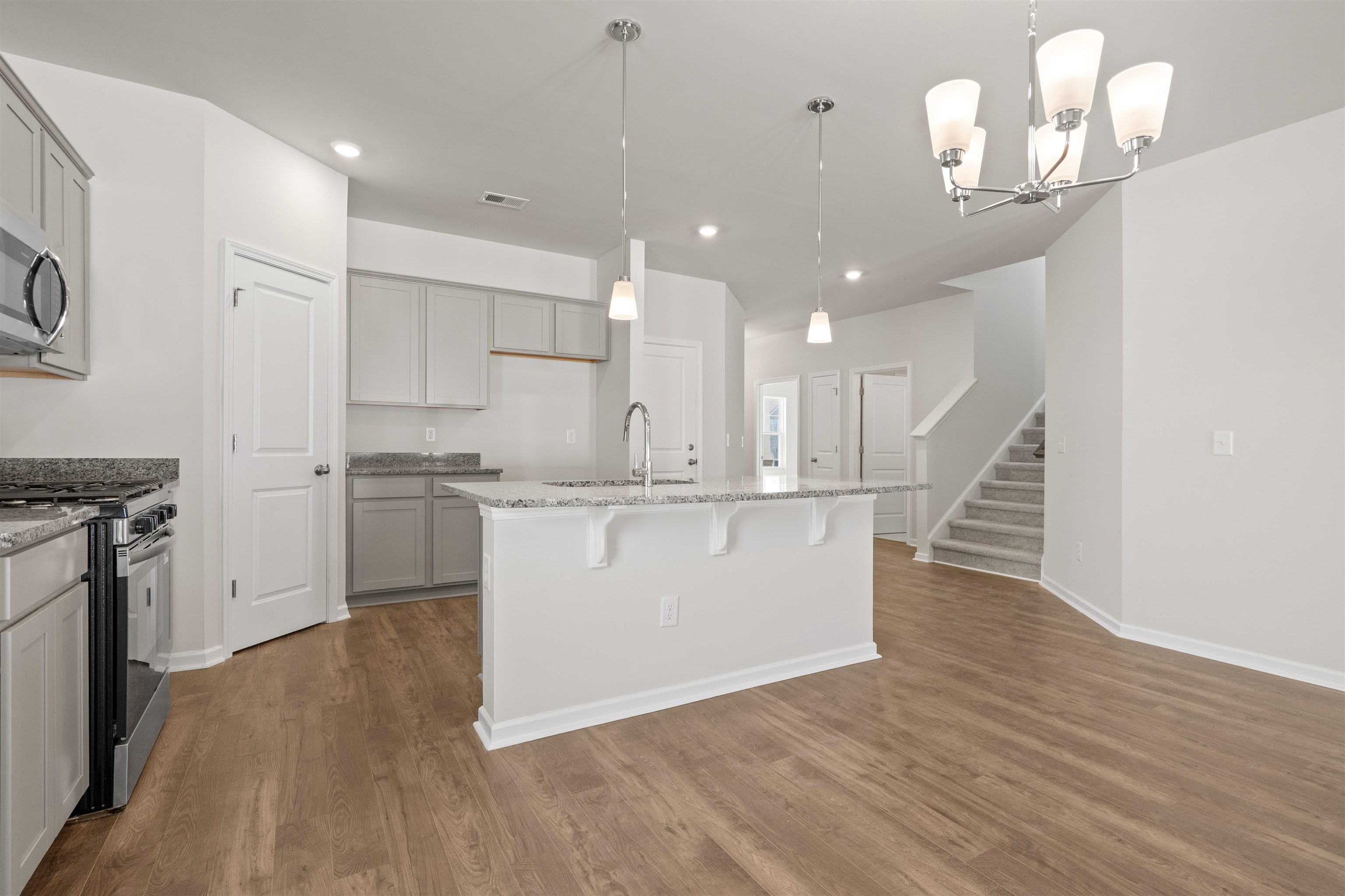 2491 Campton Loop Conway, SC 29527 - Photo 10 of 38 Kitchen featuring appliances with stainless steel finishes, light stone counters, pendant lighting, a chandelier, and a kitchen bar