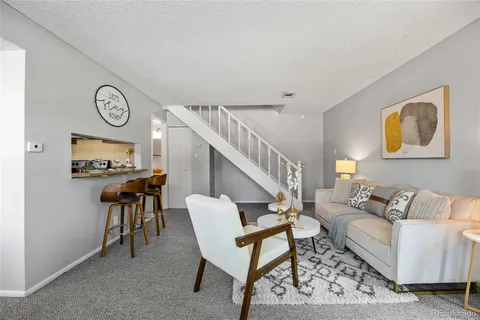 a living room with furniture a clock and a window