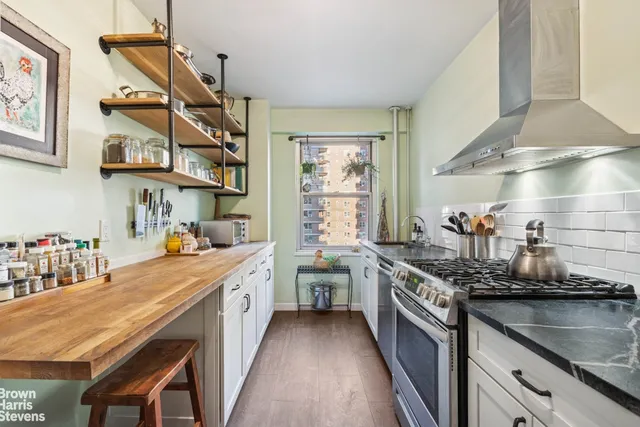 a kitchen with stainless steel appliances granite countertop a lot of counter space and wooden floors