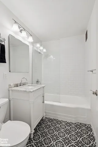 a bathroom with a sink a toilet a mirror and shower