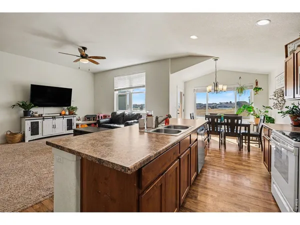 a kitchen with kitchen island a counter top space a sink appliances and a dining table