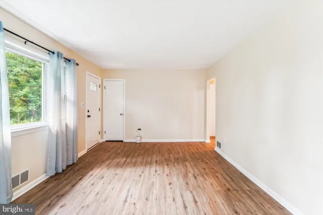 a view of a room with wooden floor and window