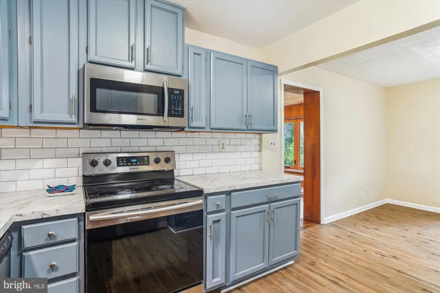 a kitchen with granite countertop cabinets stainless steel appliances and wooden floor