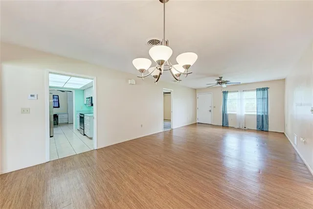 a view of a room with wooden floor and chandelier