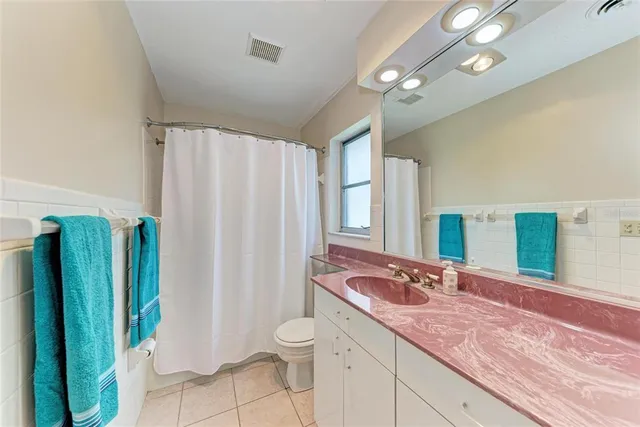 a bathroom with a granite countertop sink a toilet and a mirror