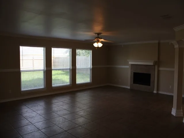 an empty room with windows and fireplace