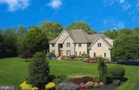 a view of a white house with a big yard and potted plants