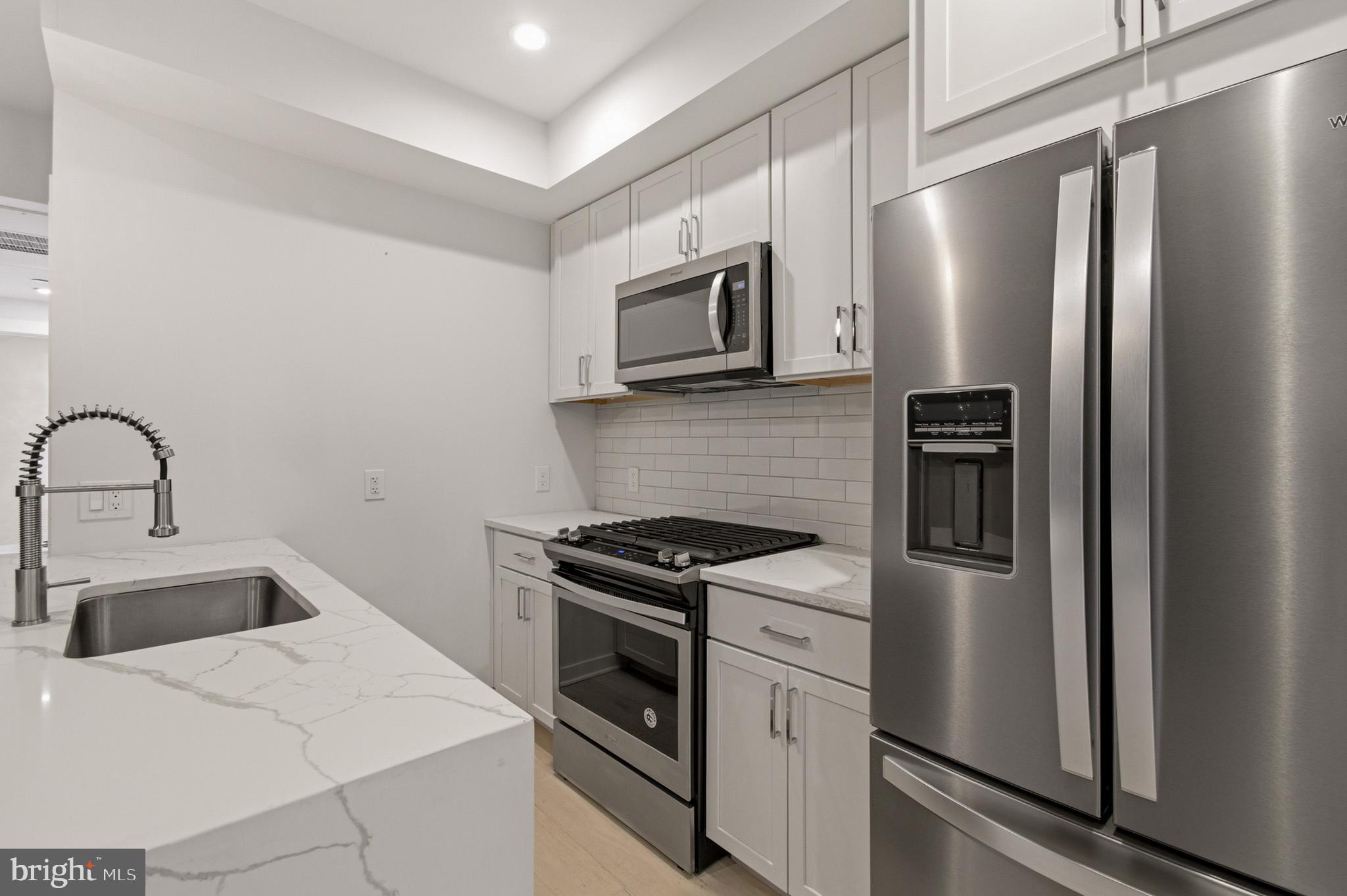 531 Kennedy Street Northwest, Unit 3 Washington, DC 20011 - Photo 12 of 19 a kitchen with stainless steel appliances a refrigerator stove and microwave