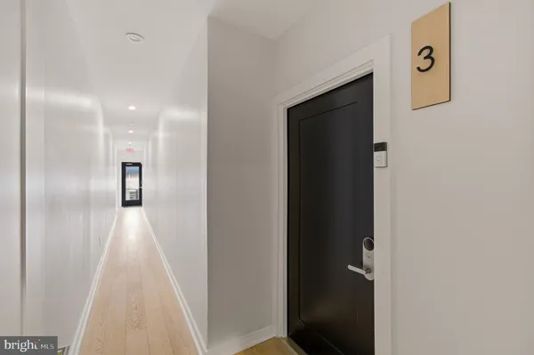 a view of a hallway with wooden floor