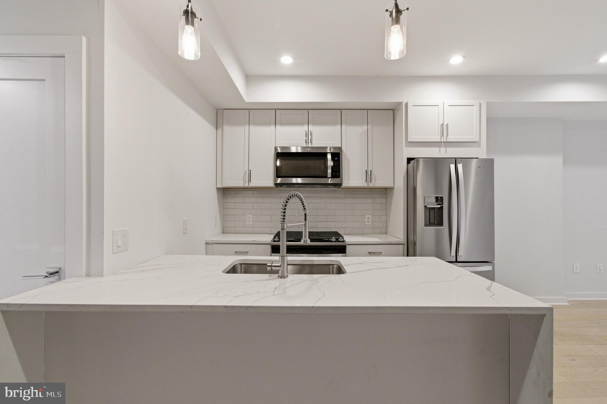531 Kennedy Street Northwest, Unit 3 Washington, DC 20011 - Photo 9 of 19 a kitchen with kitchen island a sink stainless steel appliances and cabinets