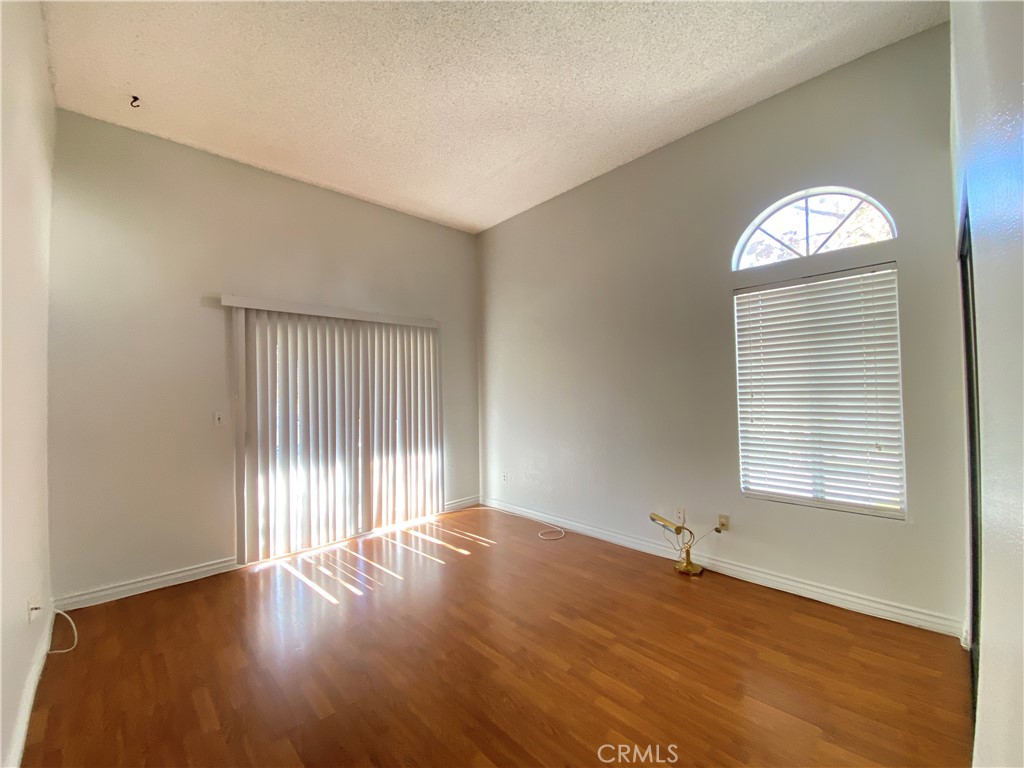 156 West Walnut Avenue, Unit A Rialto, CA 92376 - Photo 15 of 28 an empty room with wooden floor and windows