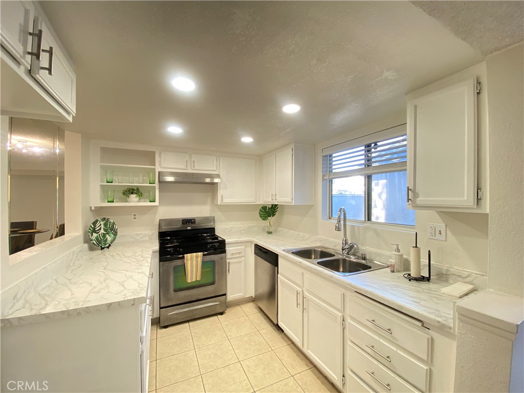 156 West Walnut Avenue, Unit A Rialto, CA 92376 - Photo 7 of 28 a kitchen with stainless steel appliances kitchen island granite countertop a sink and cabinets