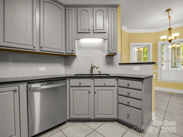 a kitchen with granite countertop white cabinets and stainless steel appliances