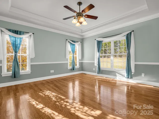 a view of an empty room with window and a kitchen