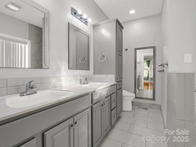 a spacious bathroom with a double vanity sink and a mirror