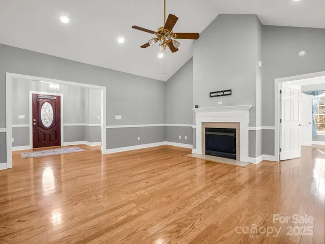 a view of empty room with wooden floor and fireplace