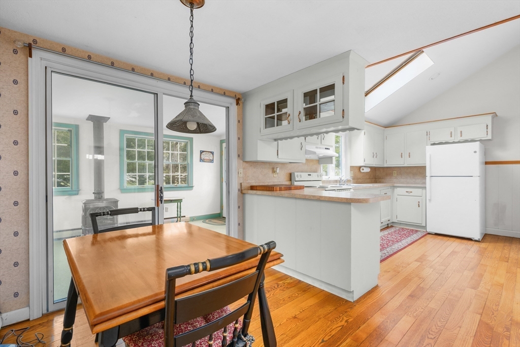 35 Wiley Lane Eastham, MA 02642 - Photo 13 of 38 a kitchen with a table chairs refrigerator and cabinets