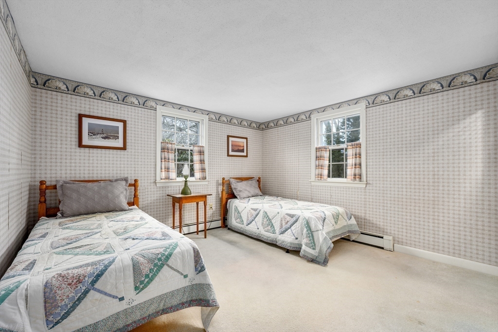 35 Wiley Lane Eastham, MA 02642 - Photo 21 of 38 a spacious bedroom with two beds and a window