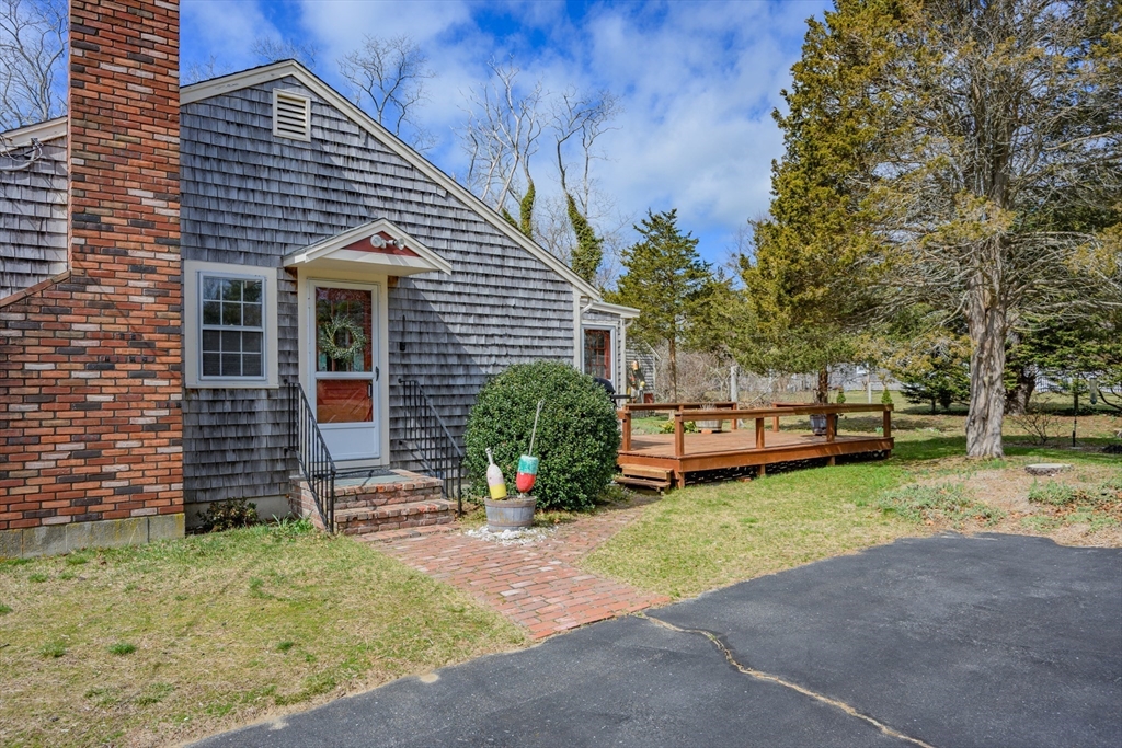 35 Wiley Lane Eastham, MA 02642 - Photo 3 of 38 a front view of house with yard and trees in the background