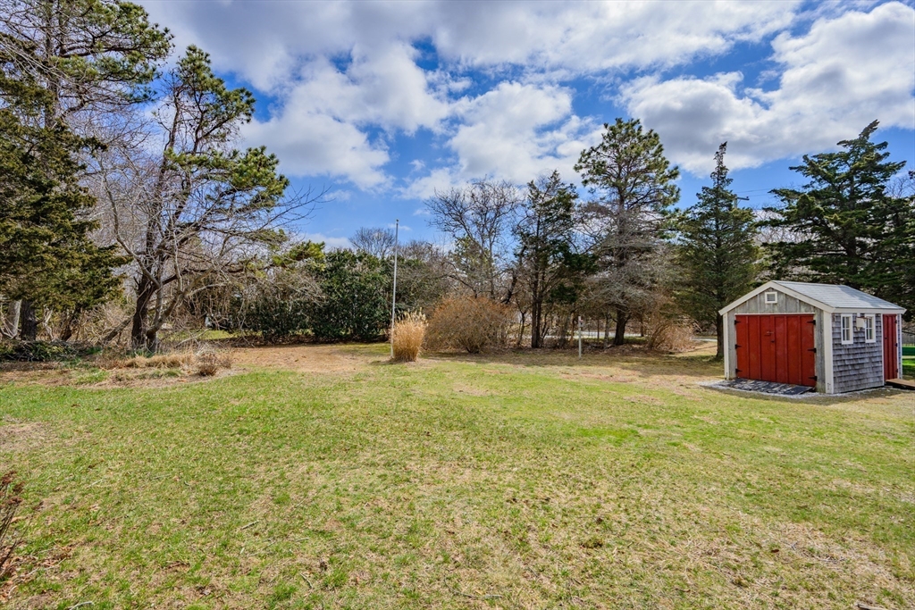 35 Wiley Lane Eastham, MA 02642 - Photo 6 of 38 a view of a tree in front of a house with a yard
