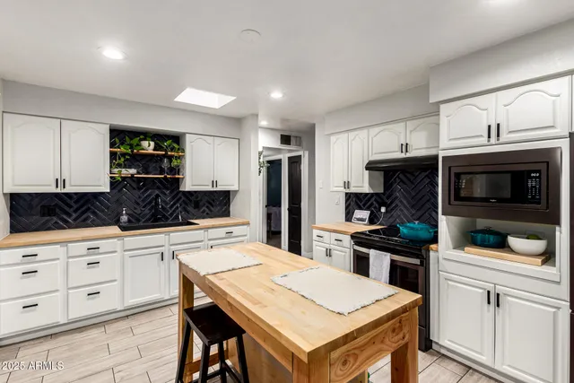 a kitchen that has a lot of cabinets a sink and appliances in it