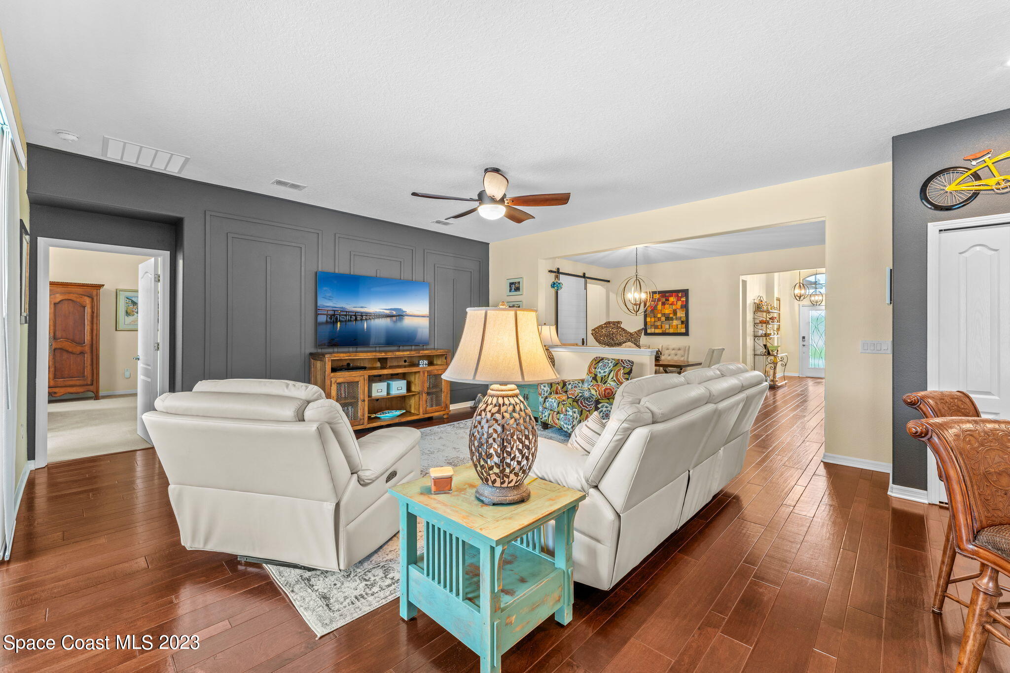 3428 Ahern Place Melbourne, FL 32940 - Photo 18 of 64 a living room with furniture a chandelier and a flat screen tv
