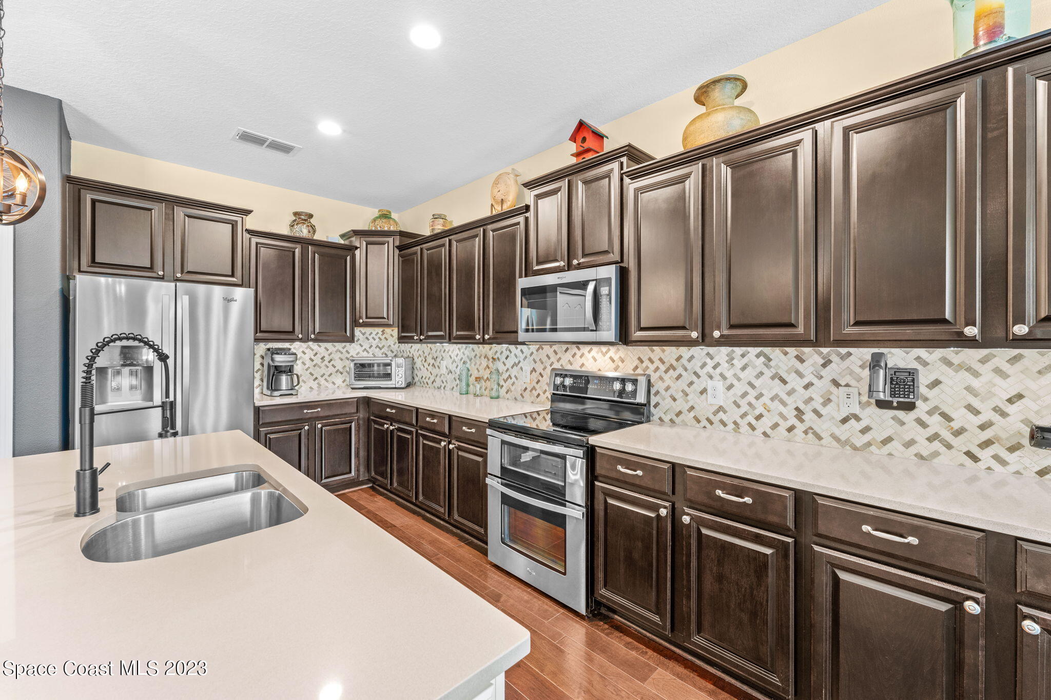 3428 Ahern Place Melbourne, FL 32940 - Photo 21 of 64 a kitchen with stainless steel appliances granite countertop a sink stove and refrigerator