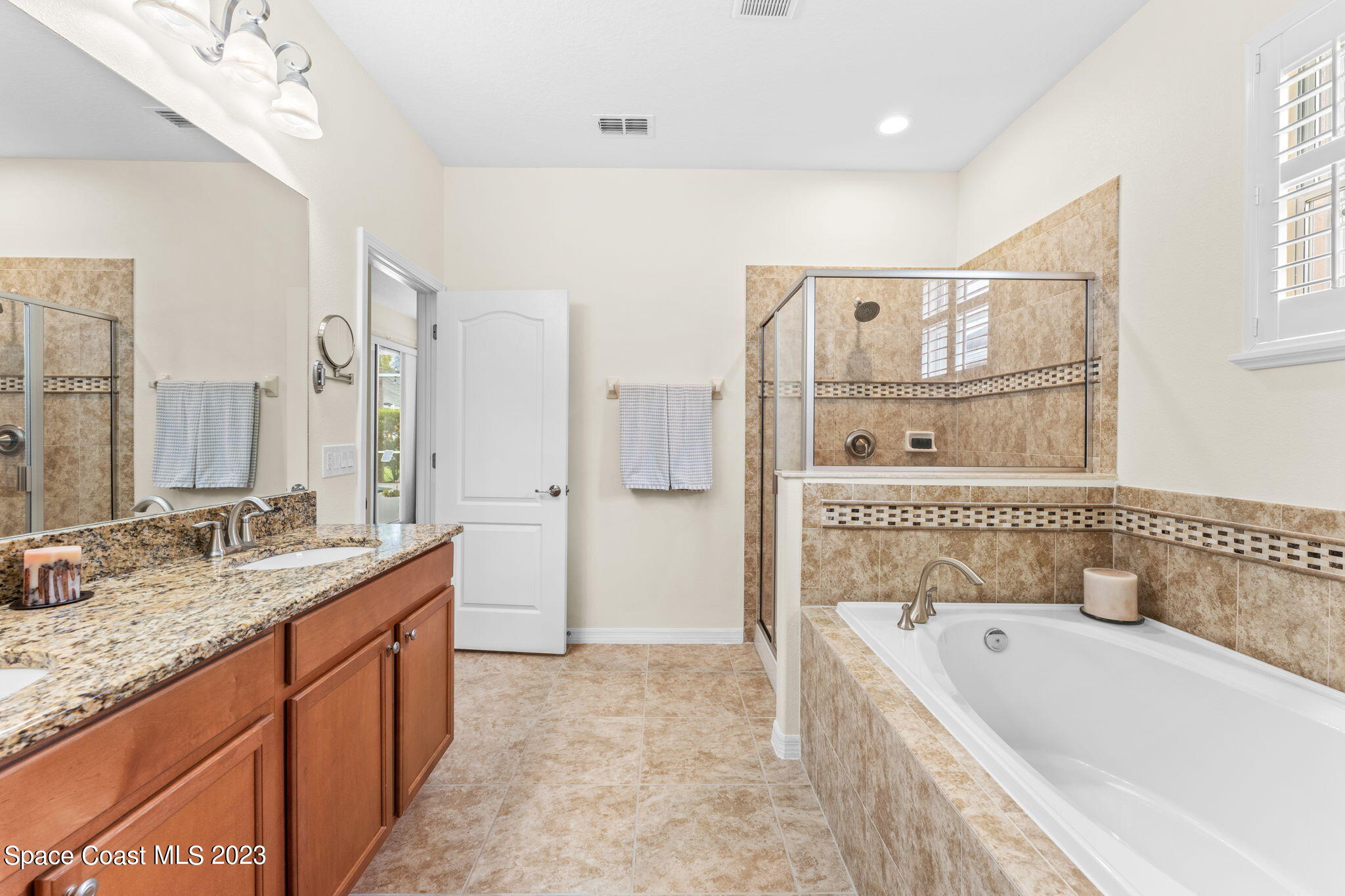 3428 Ahern Place Melbourne, FL 32940 - Photo 31 of 64 a bathroom with a granite countertop tub sink and mirror