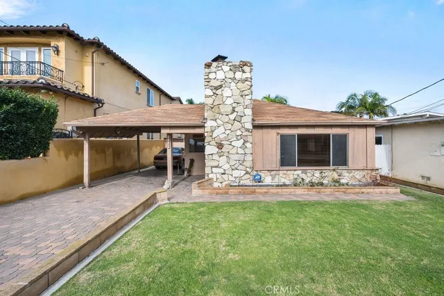 a view of a house with a yard and sitting area