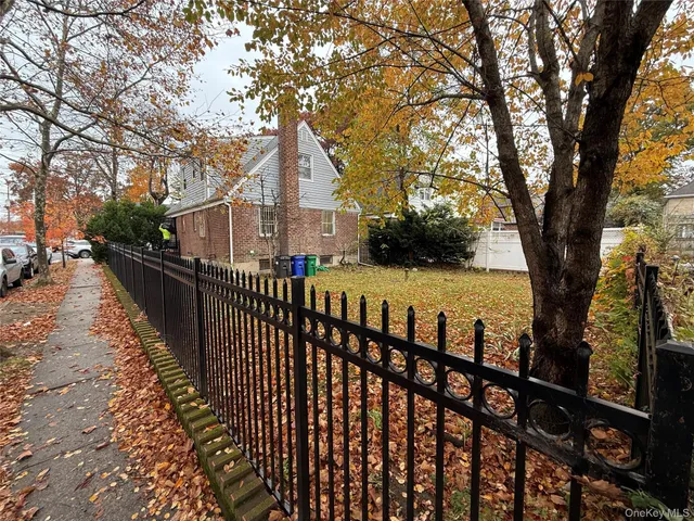 a view of house with outdoor seating and trees