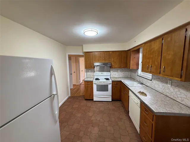 a large kitchen with a stove a sink and a refrigerator