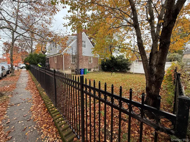 a view of a street with wooden fence