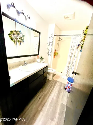 a bathroom with a sink mirror vanity and toilet