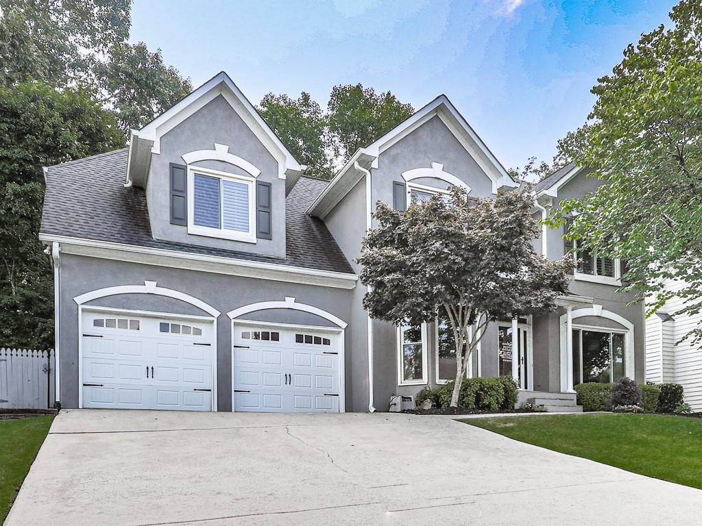 7072 Hunters Ridge Woodstock, GA 30189 - Photo 1 of 1 a front view of a house with a garden and trees