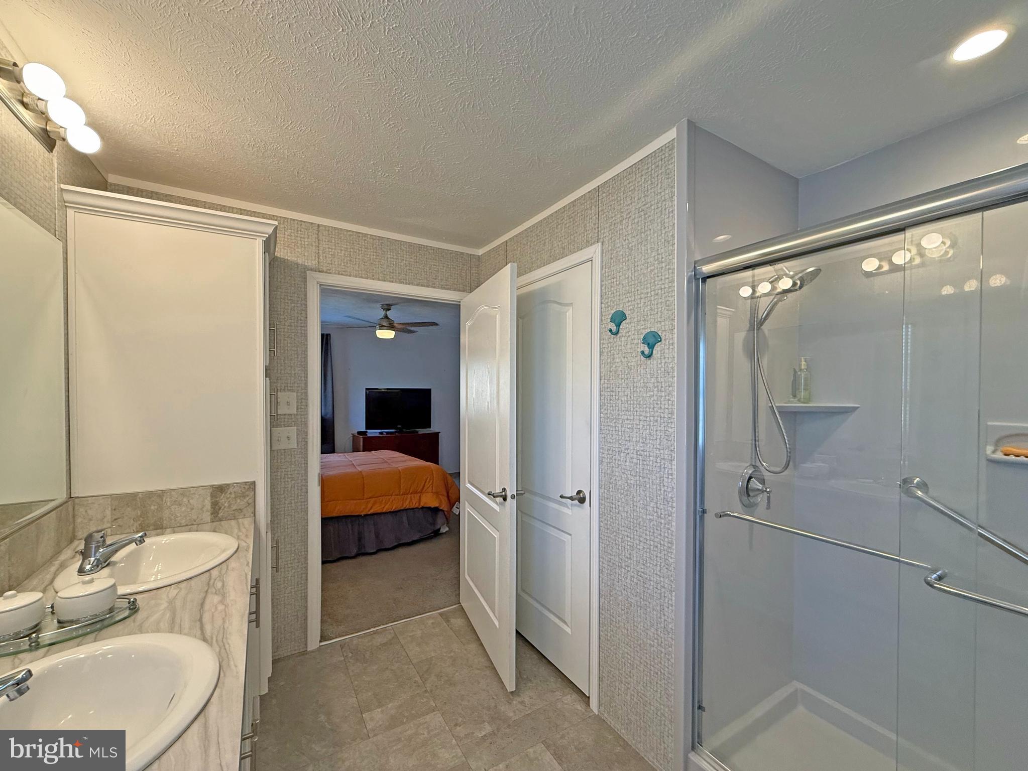 31655 Janice Road, Unit A36 Lewes, DE 19958 - Photo 15 of 32 a bathroom with a double vanity sink toilet mirror and shower