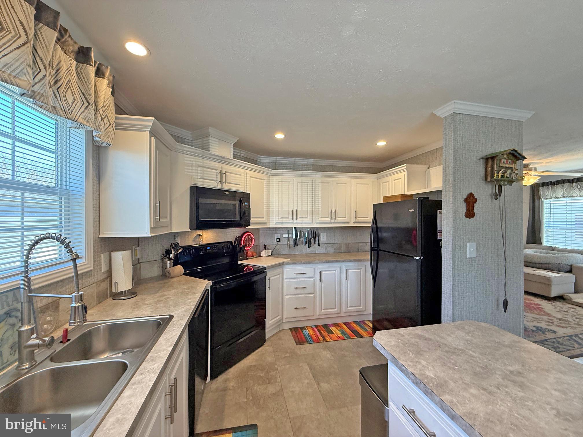 31655 Janice Road, Unit A36 Lewes, DE 19958 - Photo 9 of 32 a kitchen with stainless steel appliances kitchen island granite countertop a sink stove and refrigerator