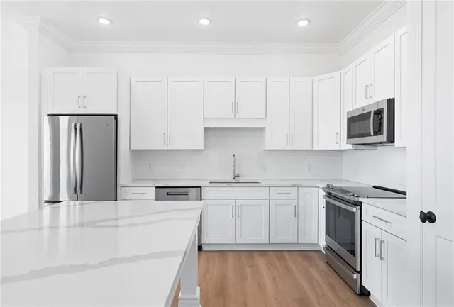 a view of kitchen with stainless steel appliances refrigerator and cabinets