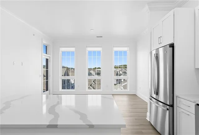 a view of an empty room with window and wooden floor