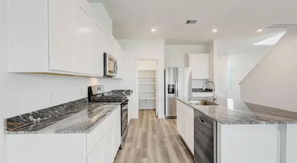 a kitchen with a sink stove top oven and refrigerator