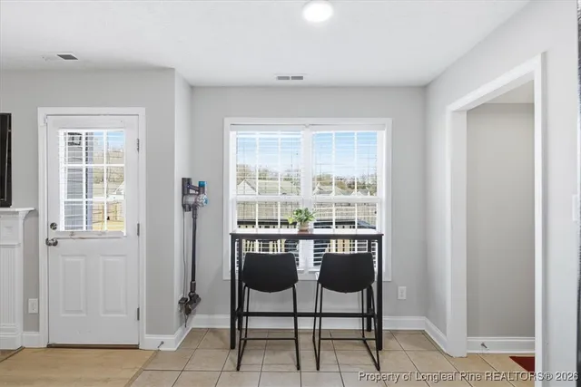 a dining room with furniture and a window