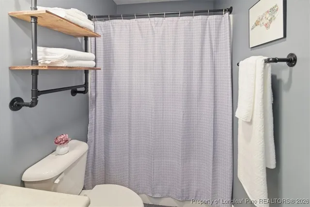a bathroom with a toilet and shower curtain
